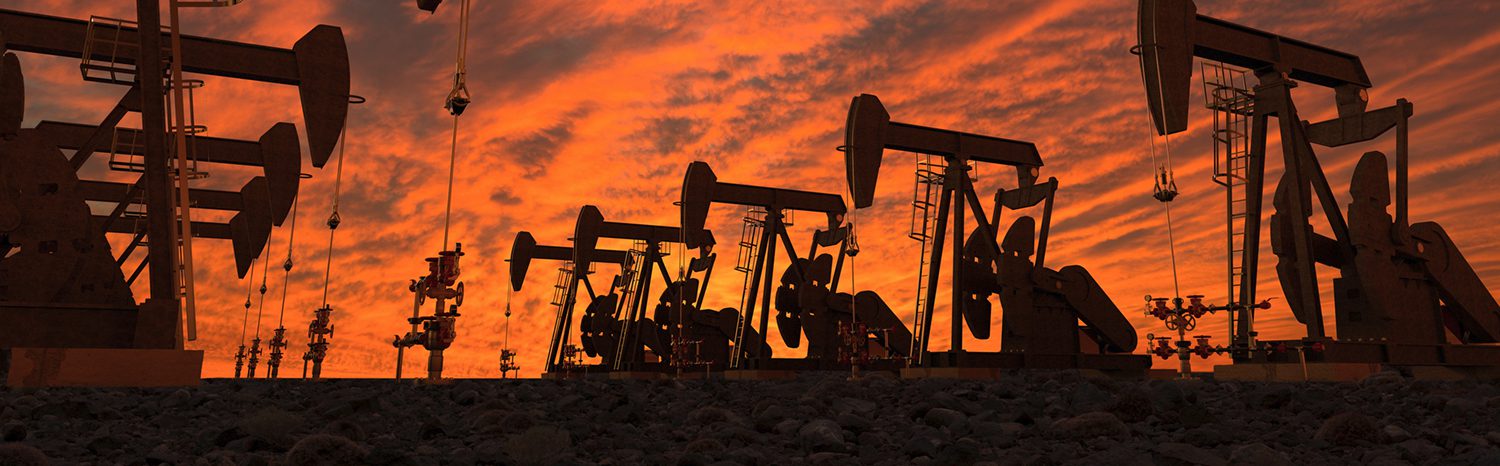 Oil pumpjacks silhouetted against a vibrant sunset sky.